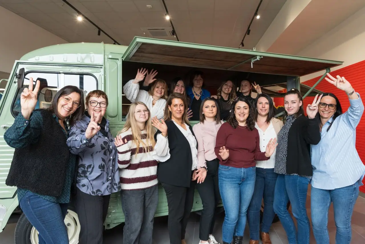 Collaborateurs devant un van rétro en concession